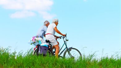 casal de idosos andando de bicicleta em paisagem verde